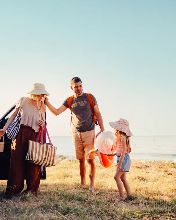 Family getting out of the car by the beach