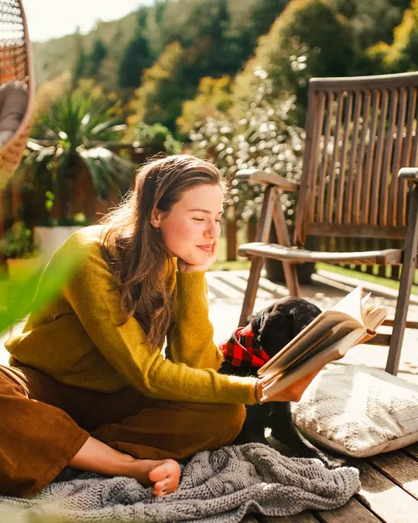Woman reading a book outside on the patio